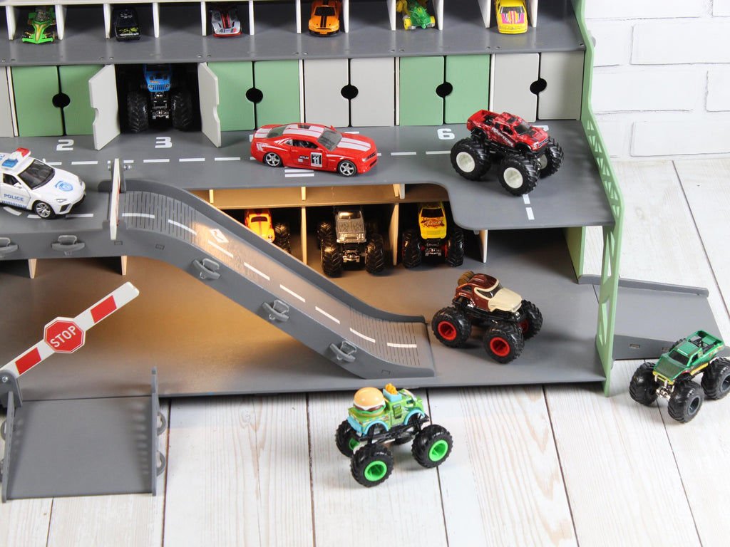 Lower section of mint wooden toy car garage with ramp, stop barrier and LED-lit parking area