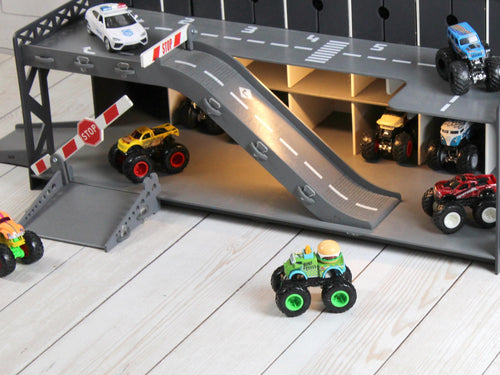 Lower section of graphite wooden toy car garage with ramp, road markings and toy cars