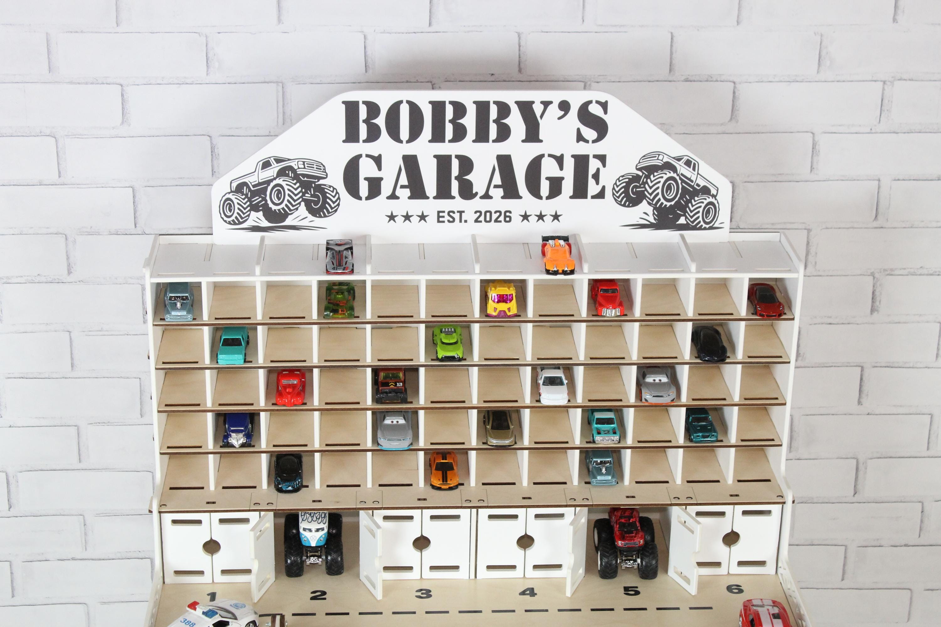 Wooden toy car storage garage with open shelves and Bobby’s Garage nameplate